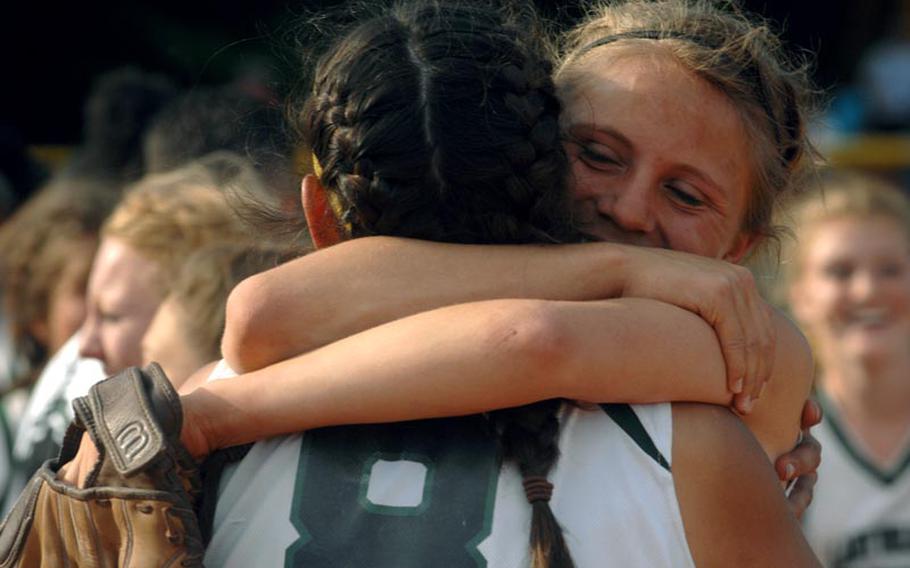 Naples softball players embrace after the last out in their 15-11 win over AFNORTH in Saturday's Division II championship game of the DODDS Europe tournament in Ramstein.