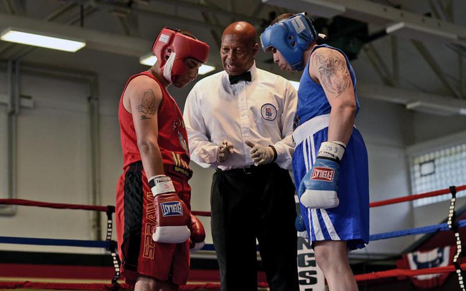 Erasmo Alarcon, left, and Roberto Rivas listen to instructions from the referee before starting their welterweight bout Saturday night during the Installation Management Command Boxing Invitational at Miesau Army Depot, Germany.