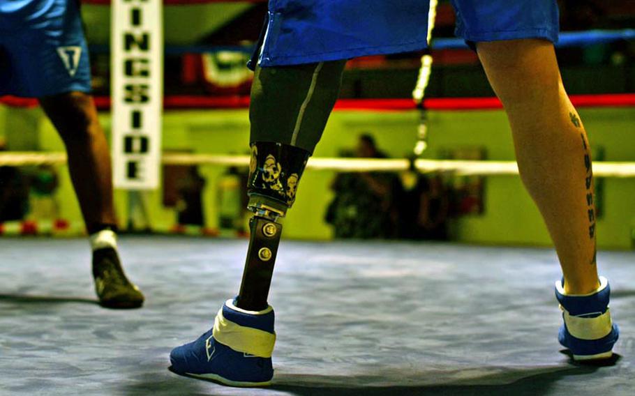 Brandon Wooldridge stands with his prosthetic leg in his fight against Wilbert Dixon in their light heavyweight bout Saturday night during the Installation Management Command Boxing Invitational at Miesau Army Depot, Germany. Wooldgridge lost his leg during a deployment to Iraq.