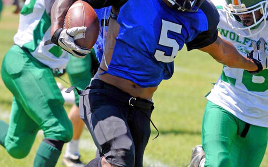 Kadena Dragons running back Emanuel Griffingives Camp Hansen Wolfpack defensive back Romeo McClarry a shove as he skirts right end during Saturday's U.S. Forces Japan-American Football League South Division regular-season finale at Camp Hansen, Okinawa. The Wolfpack rallied from an 8-2 deficit to beat the Dragons 24-8.