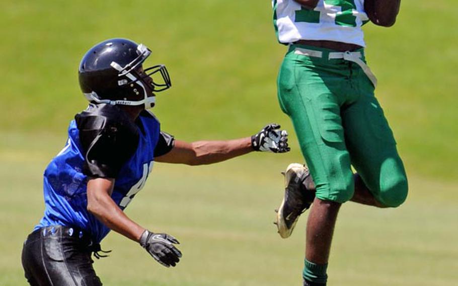 Camp Hansen Wolfpack receiver Travis Killing hauls in a Daren Monk pass as Kadena Dragons cornerback David Bright watches during Saturday's U.S. Forces Japan-American Football League South Division regular-season finale at Camp Hansen, Okinawa. The Wolfpack rallied from an 8-2 deficit to beat the Dragons 24-8.