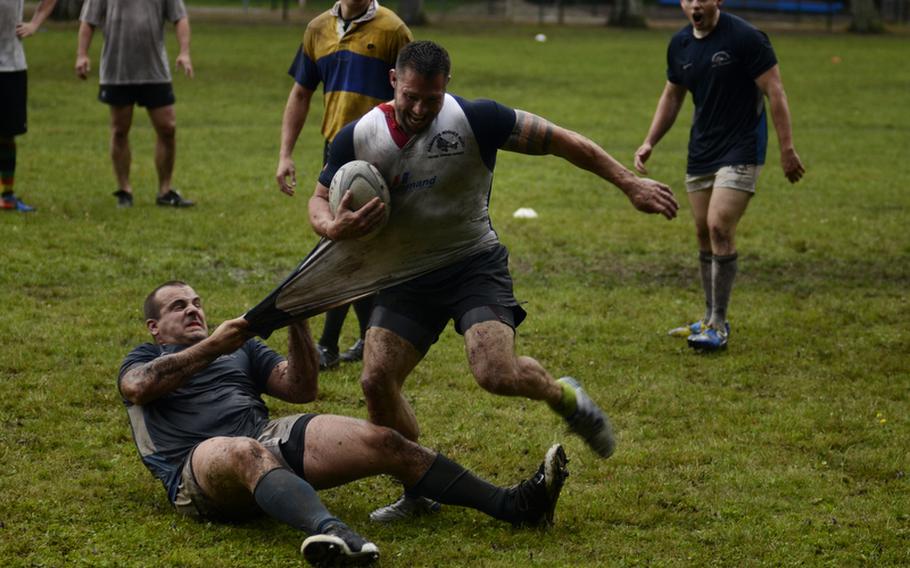Mark "Rhino" Howder tries to escape defender Chad King during a rugby practice session of the Ramstein Rogues at Ramstein Air Base.
