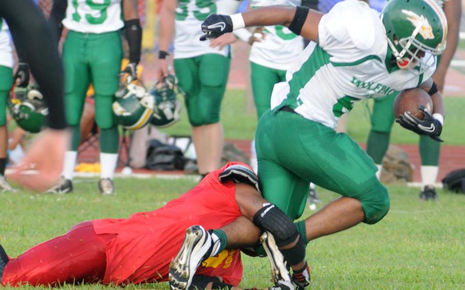Camp Hansen Wolfpack running back Rodney Hunt gets wrapped up by Camp Foster Bulldogs defender Courtney Parker during Saturday's U.S. Forces Japan-American Football League South Division championship game at Camp Foster, Okinawa. The defending champion Bulldogs blanked the Wolfpack 32-0 to advance to their third Torii Bowl league title game in four years.