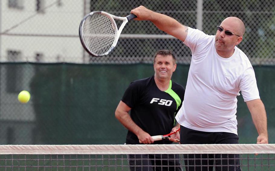 Marc Goulat of Kaiserslautern returns a shot in the men's doubles final at the U.S. Forces-Europe tennis finals in Heidelberg, Germany, Saturday, as partner Metin Karaca of Heidelberg watches. The pair fell to Alison Spain and Brett Freedman of Ramstein 6-3, 4-6, 6-4.