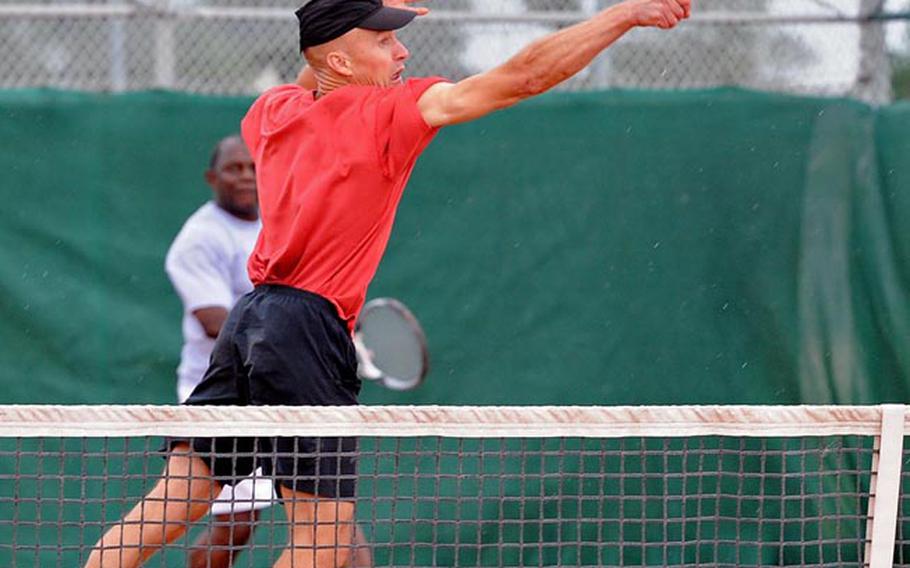 Kirk Madgic of Vicenza leaps high to return a shot in a men's doubles semifinal at the U.S. Forces-Europe tennis championships in Heidelberg, Germany, Saturday, as partner Nate Strong watches. The pair lost the match, but came back to capture third.