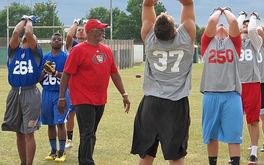 Football University clinician Thurmond Moore, a former college and NFL coach, puts players through his drill at a tackling clinic he conducted Sunday at Ansbach, Germany.