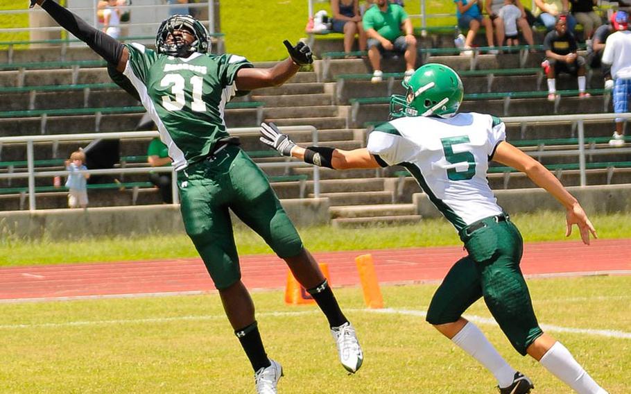 Kubasaki receiver Kareem Key lunges for a touchdown catch as Daegu defender Caleb Page can only watch during Saturday's DODDS Pacific inter-district, inter-division football game at Camp Foster, Okinawa. The Dragons routed the Warriors 39-8.