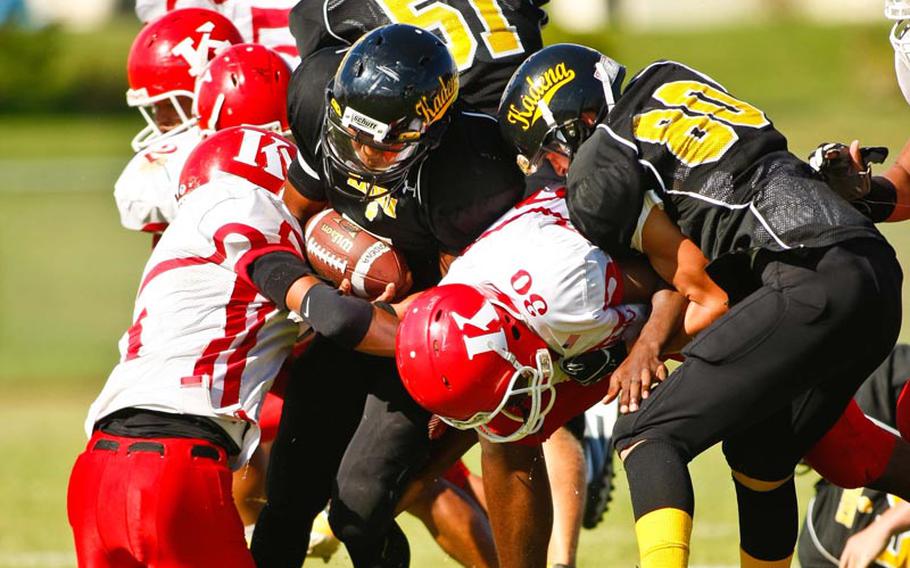 Kadena ball carrier Maverick Giron finds himself surrounded by a mass of humanity during Saturday's DODDS Pacific Division I football game at Camp Foster, Okinawa. Kadena routed Kinnick 42-0.