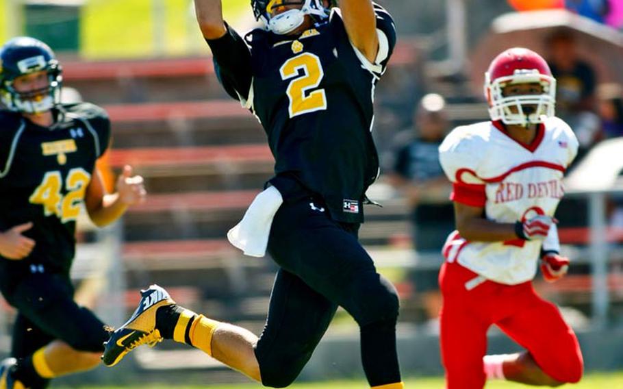 Kadena Panthers receiver Joey Dyer hauls in a 55-yard touchdown pass, his third of the season, as teammate Joshua Garrick and Nile C. Kinnick defender Marvin Newbins watch during Saturday's DODDS Pacific Division I football game at Camp Foster, Okinawa. Kadena routed Kinnick 42-0.