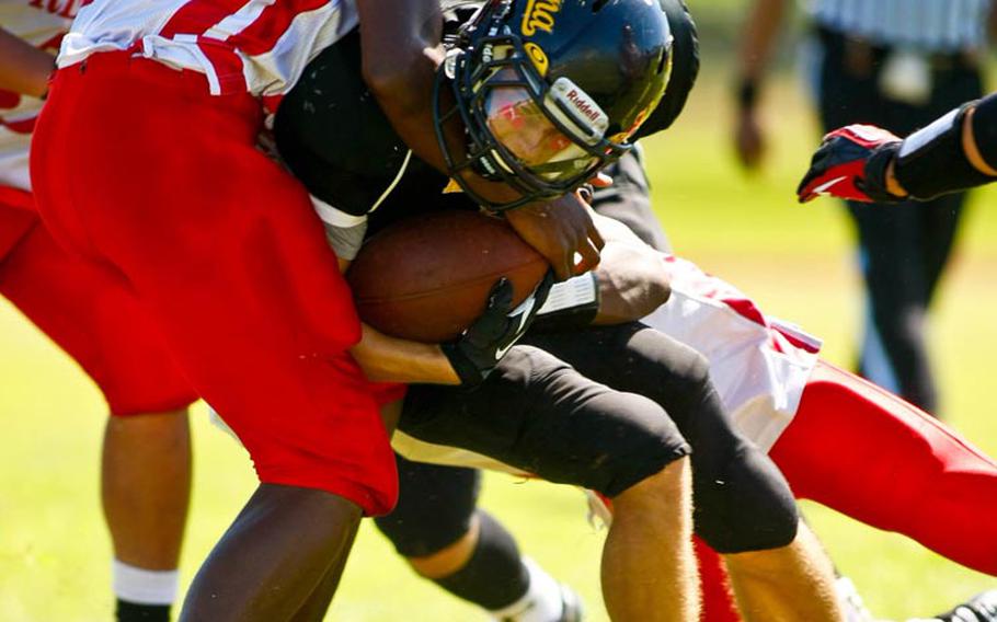 Kadena running back Justin Sego is tackled by Nile C. Kinnick  defender D'Cory Joseph during Saturday's DODDS Pacific Division I football game at Camp Foster, Okinawa. Kadena routed Kinnick 42-0.