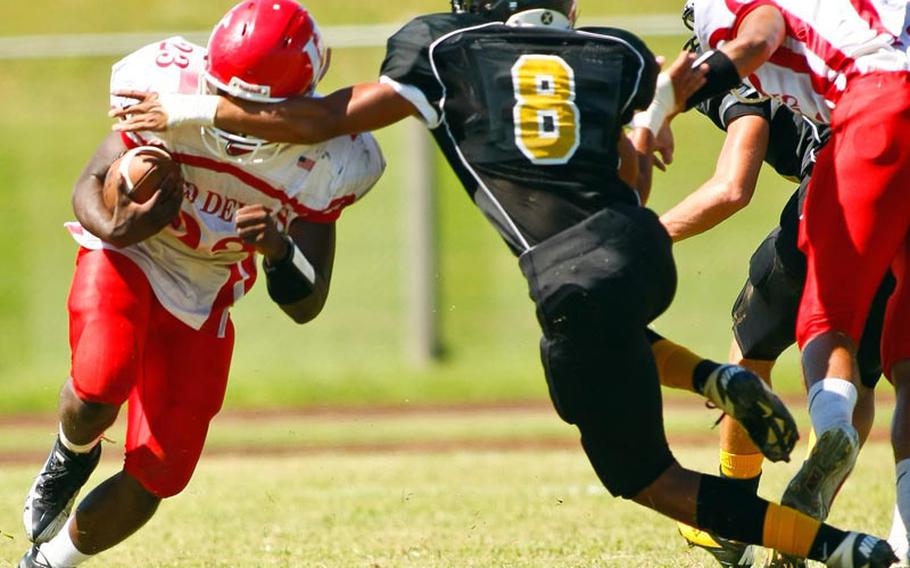 Nile C. Kinnick running back Marcus Boatwright gets a face full of Kadena Panthers defender Perry McNeil's left arm during Saturday's DODDS Pacific Division I football game at Camp Foster, Okinawa. Kadena routed Kinnick 42-0.