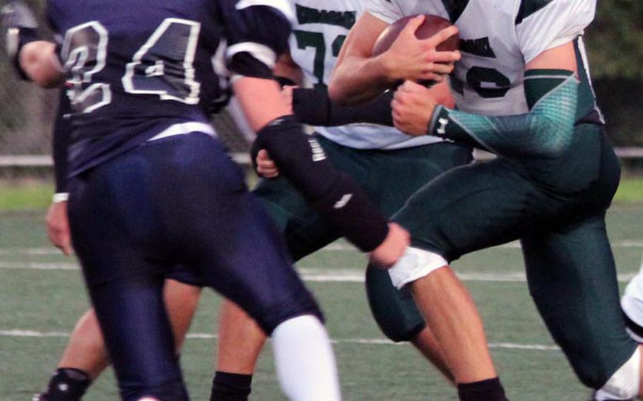 Kubasaki Dragons quarterback Tyler Smith takes off with the ball as Seoul American Falcons defender Devyn Williams closes in during Saturday's DODDS Pacific Division I football game at South Post, Yongsan Garrison, South Korea. The Dragons edged the Falcons 12-6.