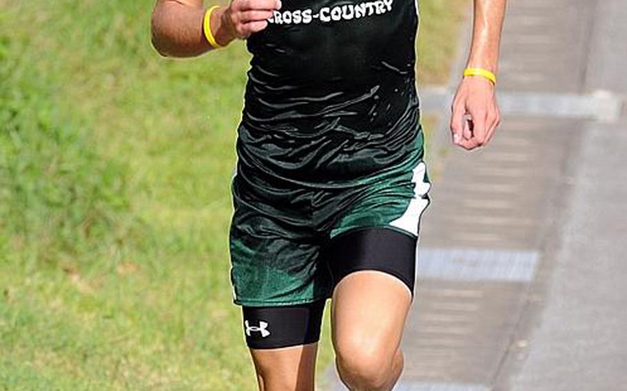 Kubasaki Dragons sophomore and reigning Far East cross-country champion Erik Armes negotiates the final hill approaching the finish line of the Okinawa Activities Council season-opening meet at Kadena Air Base, Okinawa. Visible on Armes&#39; right leg is a compression sleeve to help him continue rehabilitating from a stress fracture suffered last spring.