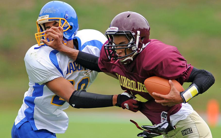 Baumholder quarterback Ben McDaniels, right, tries to keep Sigonella's Antonio Garcia at arm's length as he rushes for yardage in a Division III game at Baumholder on Saturday. Baumholder won 29-13.