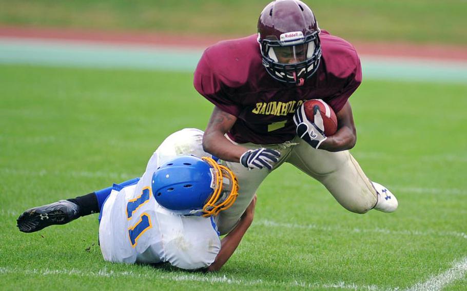 Sigonella's Collin Gantt, left, brings down Baumholder's Anthony Hendrix in a Division III game in Baumholder on Saturday. The Buccaneers defeated the visiting Jaguars 29-13.
