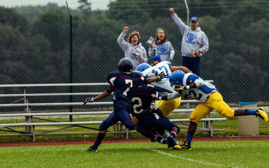 Ansbach's Xavier Cage is finally tackled by Bitgurg's CJ Evans and Shawn Ortiz after a big gain with assistance from DeMar Flake.