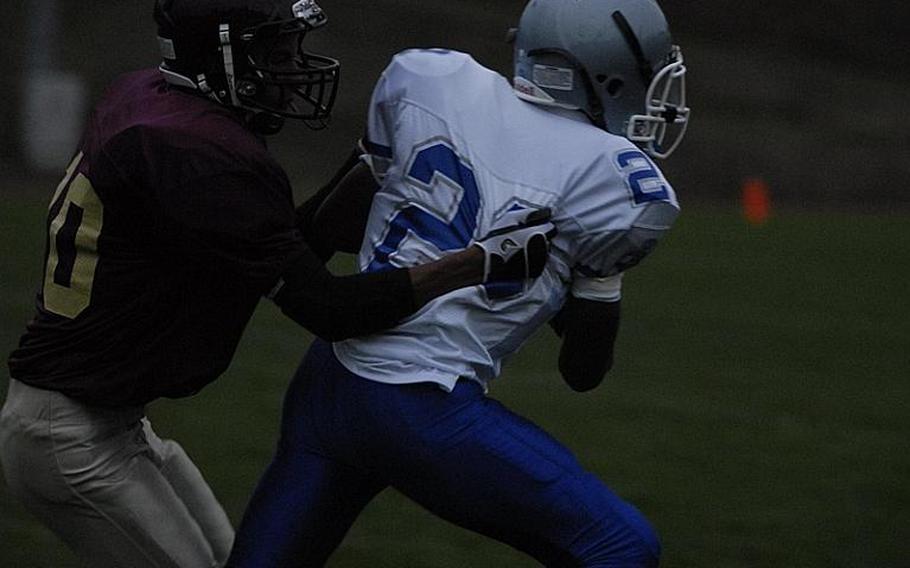 Brussels senior Kristian Javier tries to shake off Baumholder's Ben McDaniels in Friday night Division-III DODDS-Europe football. Brussels fell to the Bucs, 57-6.