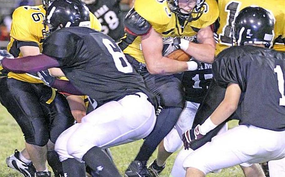 American School In Japan receiver Henry Wallrapp  fights his way through Zama American defenders Osie Cruz, right, and Chad Wilder during Friday's Kanto Plain Association of Secondary Schools football game at Camp Zama, Japan. ASIJ won 24-8.