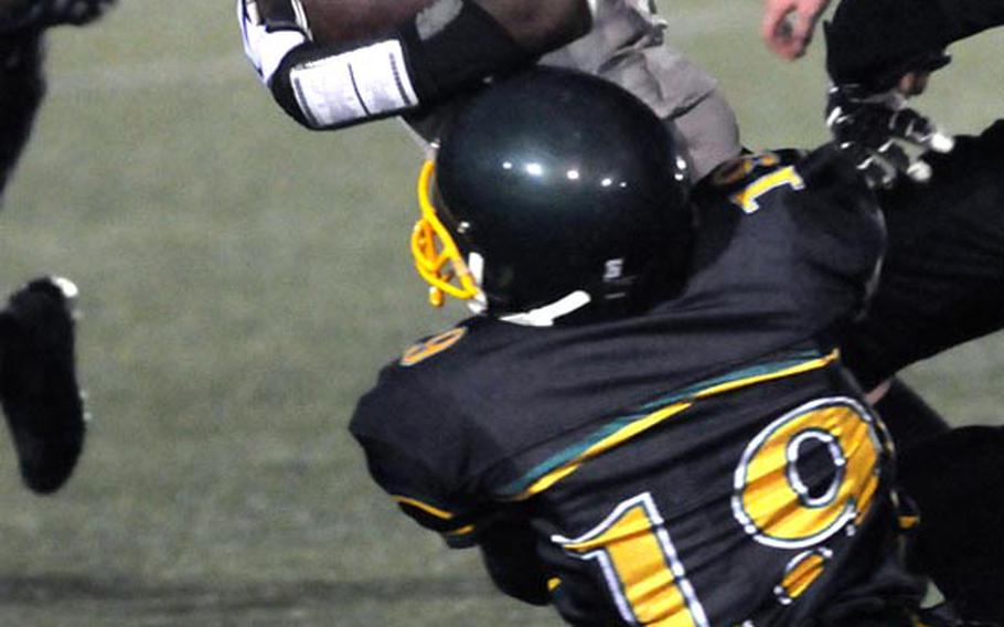 Daegu running back Ronald McLean gets dragged down by Robert D. Edgren defender Ben Warren during Saturday's DODDS Pacific Far East Division II high school football game at Camp Walker, South Korea. The Eagles won 30-8, clinching berths for both Edgren and Zama in the Nov. 10 D-II title game.