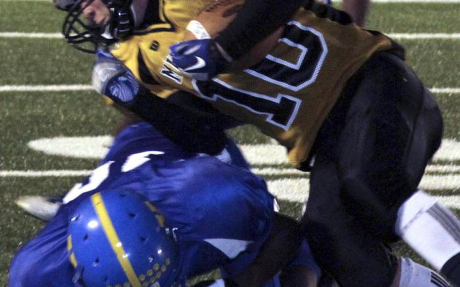 Yokota defender J.J. Henderson tackles American School In Japan running back Haru Kent during Friday's Kanto Plain Association of Secondary Schools football game at Yokota Air Base, Japan. Yokota won 42-7, sweeping the season series from ASIJ for the first time since 2007.