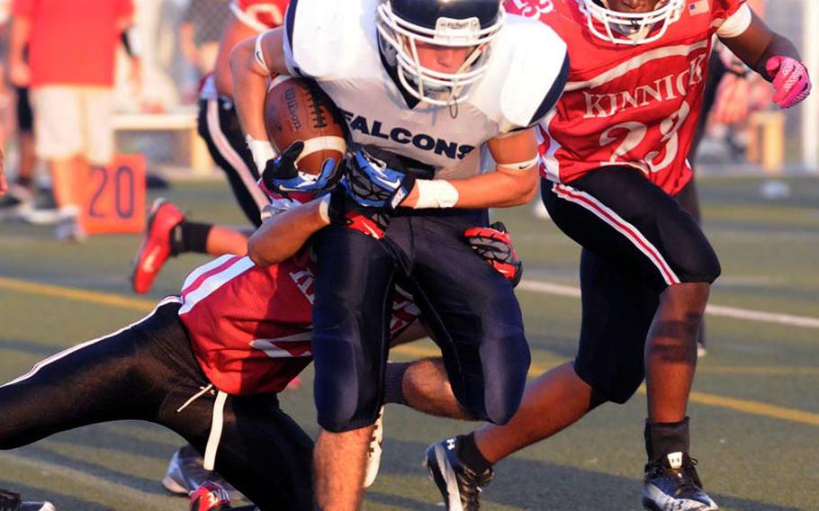 Seoul American running back Alex McDonald gets tackled by Nile C. Kinnick defender Marvin Newbins  as Kinnick's Marcus Boatwright gives chase during Saturday's Far East Division I football game at Yokosuka Naval Base, Japan. Kinnick beat the Falcons 27-0 to stay alive for a berth in the D-I title game on Nov. 17.