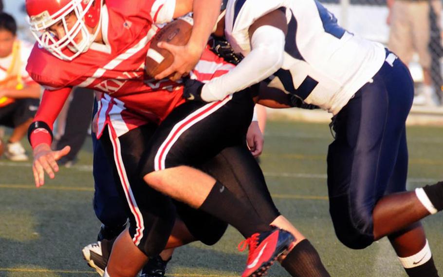 Nile C. Kinnick quarterback Greg Bacon gets tackled by Seoul American defender Brandon Roseborough during Saturday's Far East Division I football game at  Yokosuka Naval Base, Japan. Kinnick beat the Falcons 27-0 to stay alive for a berth in the D-I title game on Nov. 17.
