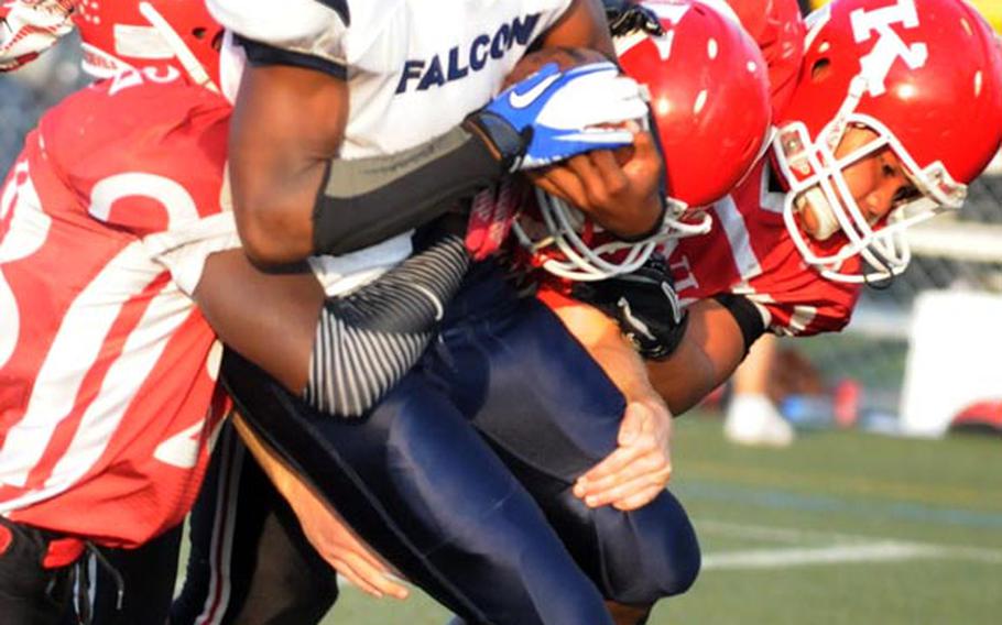 Seoul American running back Ronald Dogan gets tackled by Nile C. Kinnick defenders Dakota Rogers, Marcus Boatwright and Jesse Ecklund during Saturday's Far East Division I football game at Yokosuka Naval Base, Japan.