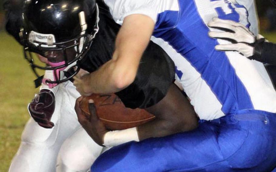 Zama American running back David Coleman gets hauled down by Yokota efender Matt Adams during Friday's DODDS Japan/Kanto Plain Association of Secondary Schools football game at Camp Zama, Japan. Yokota won 39-12.