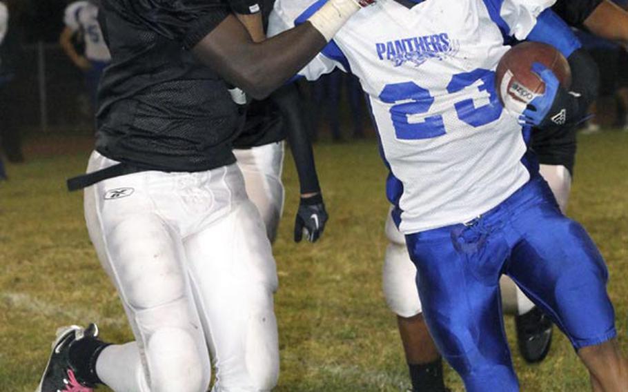 Yokota running back Morgan Breazell gets a mouthful of Zama American defender David Coleman's glove during Friday's DODDS Japan/Kanto Plain Association of Secondary Schools football game at Camp Zama, Japan. Yokota won 39-12 and clinched its 12th DODDS Japan and Kanto titles on coach Tim Pujol's watch.
