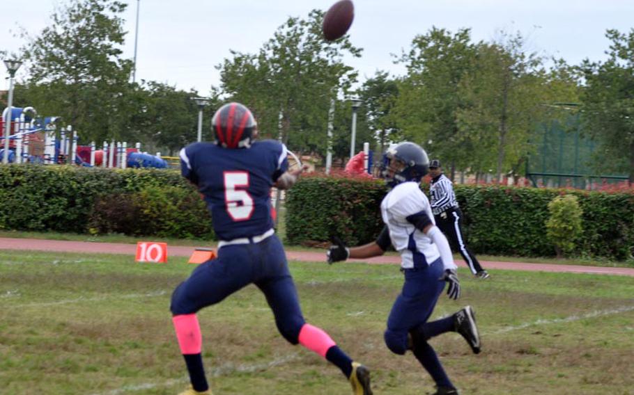 Aviano's Elijah Smith runs under a pass from Mike Trujillo for a 38-yard completion Saturday, but the Saints lost to Bitburg, 50-6.