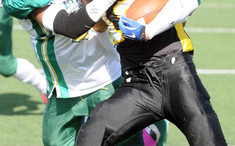 American School In Japan Mustangs running back Haru Kent wrestles with Robert D. Edgren Eagles defender Khalil Williams during Saturday's high school football game at American School In Japan Chofu campus, Tokyo. ASIJ won 47-14 to sweep the season series from the Eagles.