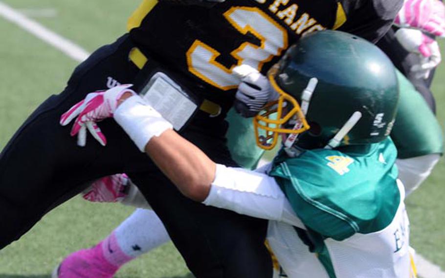 American School In Japan running back Ken Yajima gets hauled down by Robert D. Edgren defender Tyrone Bacalso during Saturday's high school football game at American School In Japan Chofu campus, Tokyo. ASIJ won 47-14 to sweep the season series from the Eagles.