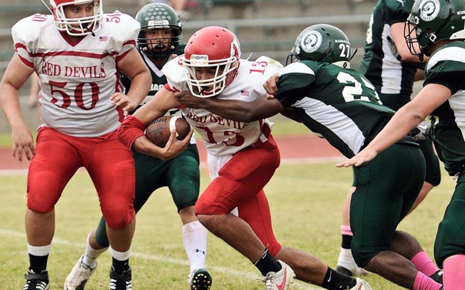 Nile C. Kinnick quarterback Dustin Wilson tries to elude the tackle of Kubasaki defender Tyshon Butler  during Saturday's DODDS Pacific Far East Division I regular-season game at Camp Foster, Okinawa. The Dragons won 28-14.