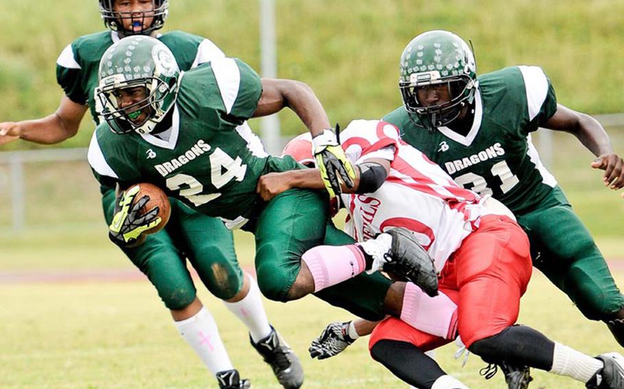 Kubasaki running back Jarrett Mitchell slithers through the tackle of a Nile C. Kinnick defender during Saturday's DODDS Pacific Far East Division I regular-season game at Camp Foster, Okinawa. Mitchell scored three times and went over 1,000 rushing yards for the season as the Dragons won 28-14, keeping charge of the race for D-I title-game berths, while eliminating the Red Devils from title contention.
