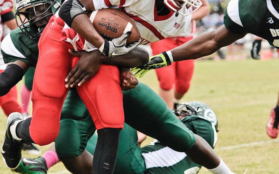 Nile C. Kinnick running back LaTendre Paylor knifes his way through Kubasaki Dragons defenders during Saturday's DODDS Pacific Far East Division I regular-season game at  Camp Foster, Okinawa. The Dragons won 28-14.