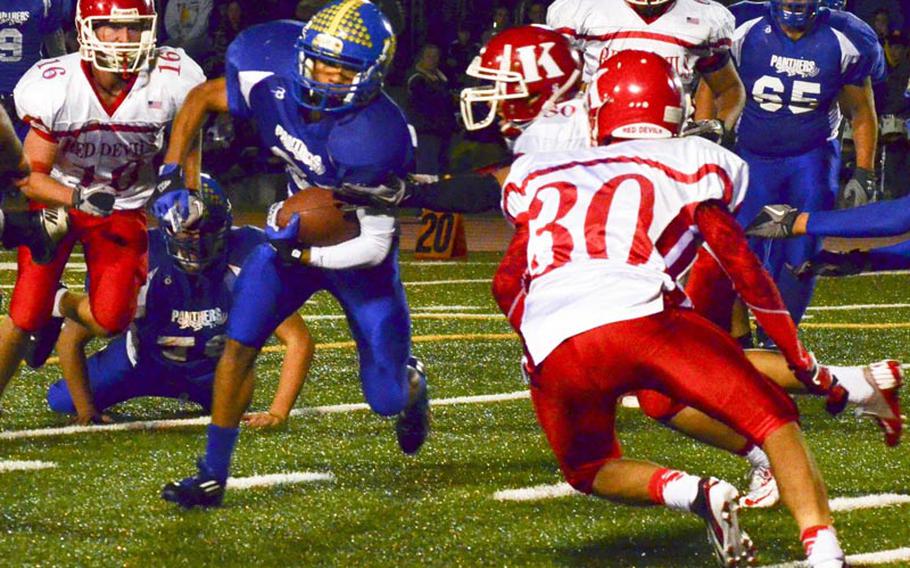 Yokota receiver Mikey Henagan slices between Nile C. Kinnick defenders Dakota Rogers and Givon Conner, right, during Friday's Far East Division I football game at Yokota Air Base, Japan. Yokota won 41-0 and secured a berth in the Far East D-I title game on Nov. 17.