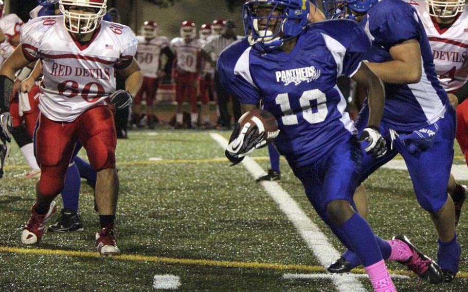 Yokota running back J.J. Henderson cuts around left end, leaving Nile C. Kinnick defender Daniel Costello in his wake during Friday's Far East Division I football game at Yokota Air Base, Japan. Yokota won 41-0 and secured a berth in the Far East D-I title game on Nov. 17.