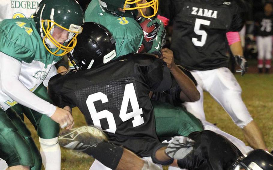 Robert D. Edgren running back Louis Murphy battles his way through Zama American defenders Chad Wilder, left, and Josh Elliot during Friday's game at Camp Zama, Japan. Zama won 40-17 and clinched host rights to the Nov. 10 D-II title game.