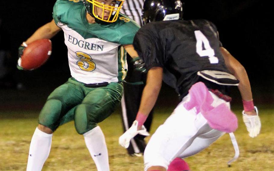 Robert D. Edgren running back Louis Murphy looks for daylight against Zama American defender Holden Limas during Friday's game at Camp Zama, Japan. Zama won 40-17 and clinched host rights to the Nov. 10 D-II title game.