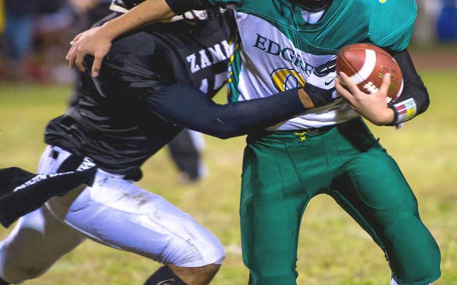 Robert D. Edgren quarterback Leo Austin tries to break free of Zama American defender Mitchell Harrison during Friday's game at Camp Zama, Japan. Zama won 40-17 and clinched host rights to the Nov. 10 D-II title game.
