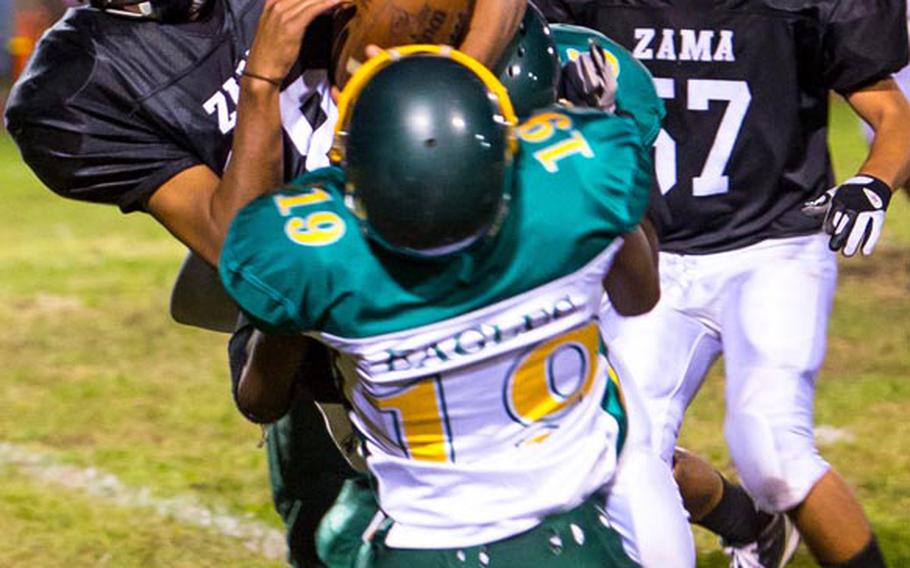 Zama American ball carrier Rafael Morales gets tackled by Robert D. Edgren defender Ben Warren  during Friday's game at Camp Zama, Japan. Zama won 40-17 and secured host rights to the Far East D-II title game on Nov. 10.