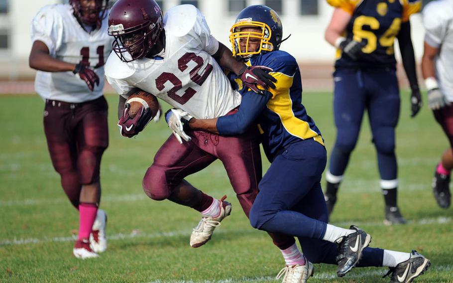 Vilseck's Shawn Peebles, left, tries to get out of the grip of Heidelberg's  Kyle Moore in Vilseck's 34-26 win over the Lions in Heidelberg, Saturday.