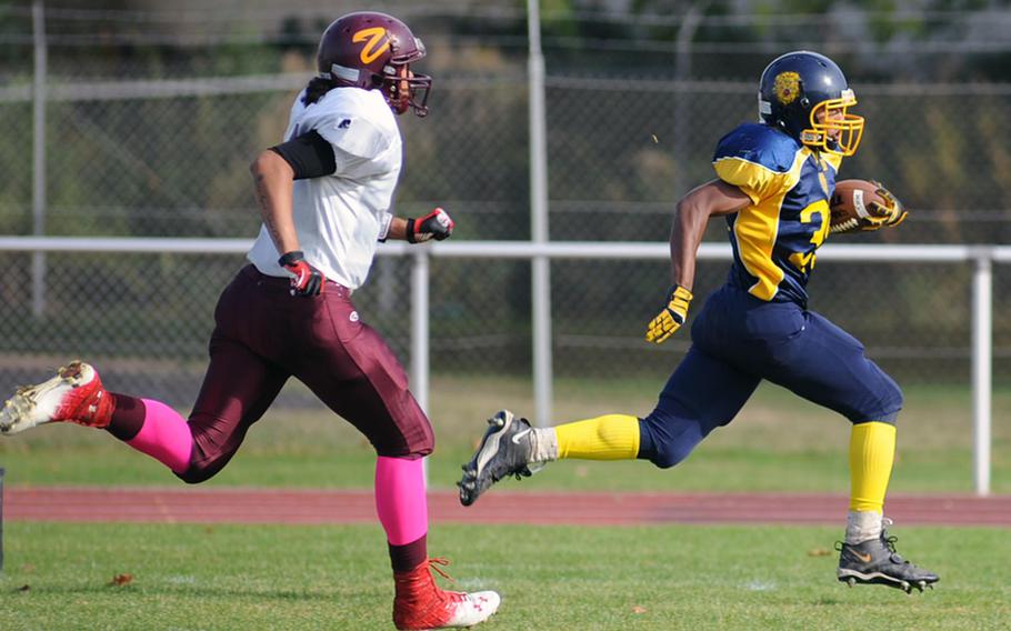 Heidelberg's Andre Brown, right, outruns Vilseck's Jeff Davis for the first touchdown of the game in Heidelberg, Saturday. The Lions fell to the visitors 34-26 in the school's final football game.