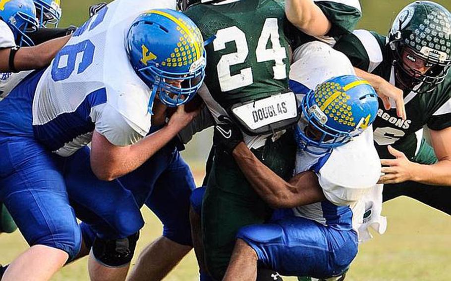 Kubasaki running back Jarrett Mitchell gets tackled by Yokota defenders Jesse Hogan, left, and Raymond Butler during Saturday's DODDS Pacific Far East Division I football game at Camp Foster, Okinawa. Yokota won 31-6.