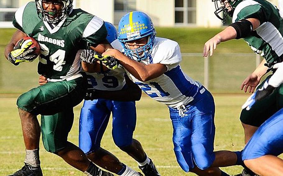 Kubasaki running back Jarrett Mitchelltries to avoid the tackles of Yokota defenders Ke'Ondre Davis and James Cortez, right, during Saturday's DODDS Pacific Far East Division I football game at Camp Foster, Okinawa. Yokota won 31-6.