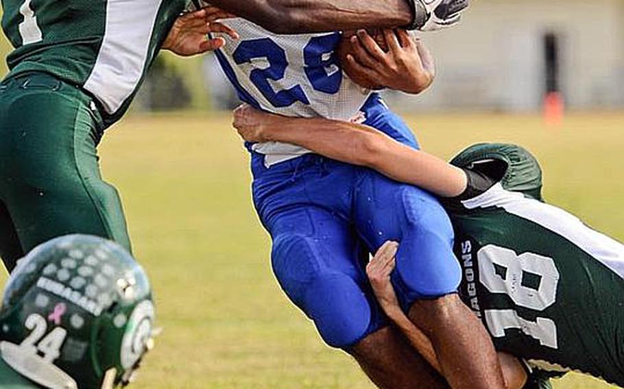 Yokota running back Donavan Ball gets wrapped up by Kubasaki defenders Jamal Ellis, left, and Justis Kosmoski during Saturda's DODDS Pacific Far East Division I football game at Camp Foster, Okinawa. Yokota won 31-6.