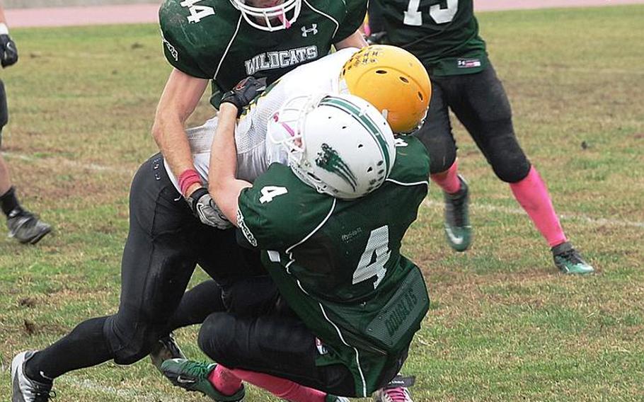 Naples' Kyle Baldree and Bryan Pfirrman, top, combine to make a tackle.