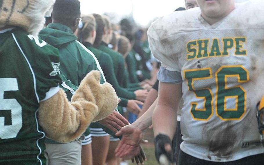 SHAPE and Naples players exchange hand shakes  and slaps after the Wildcats prevailed 21-16 over the Spartans in a Division II playoff game Saturday.