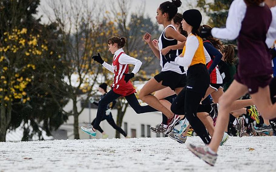 Runners in the girl& 2012 DODDS-Europe cross country championships sprint through the snow at the start of the race Saturday morning at the Rolling Hills Golf Course in Baumholder, Germany.