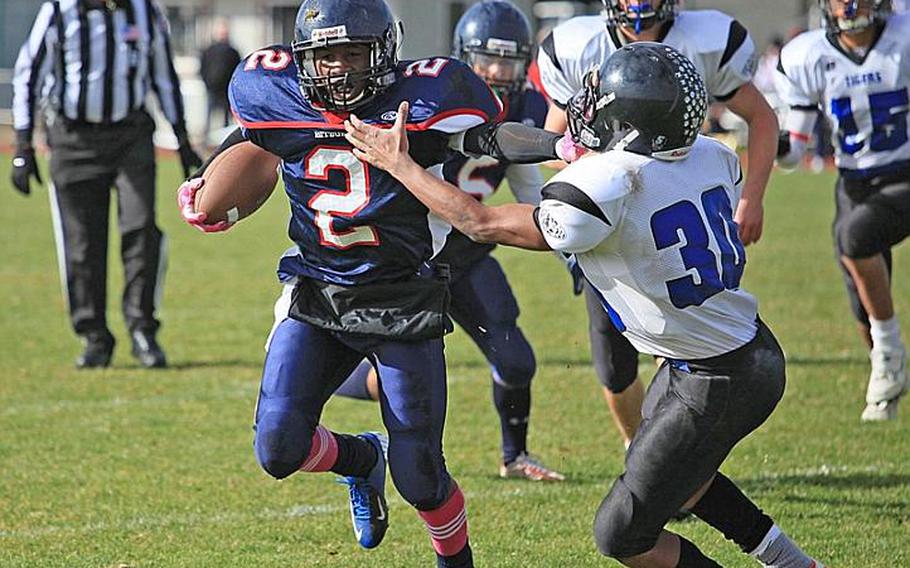 Bitburg running back C.J. Evans stiff arms Hohenfels' P.J. McCune in the first half of the Barons' 56-14 romp over the visiting Tigers.